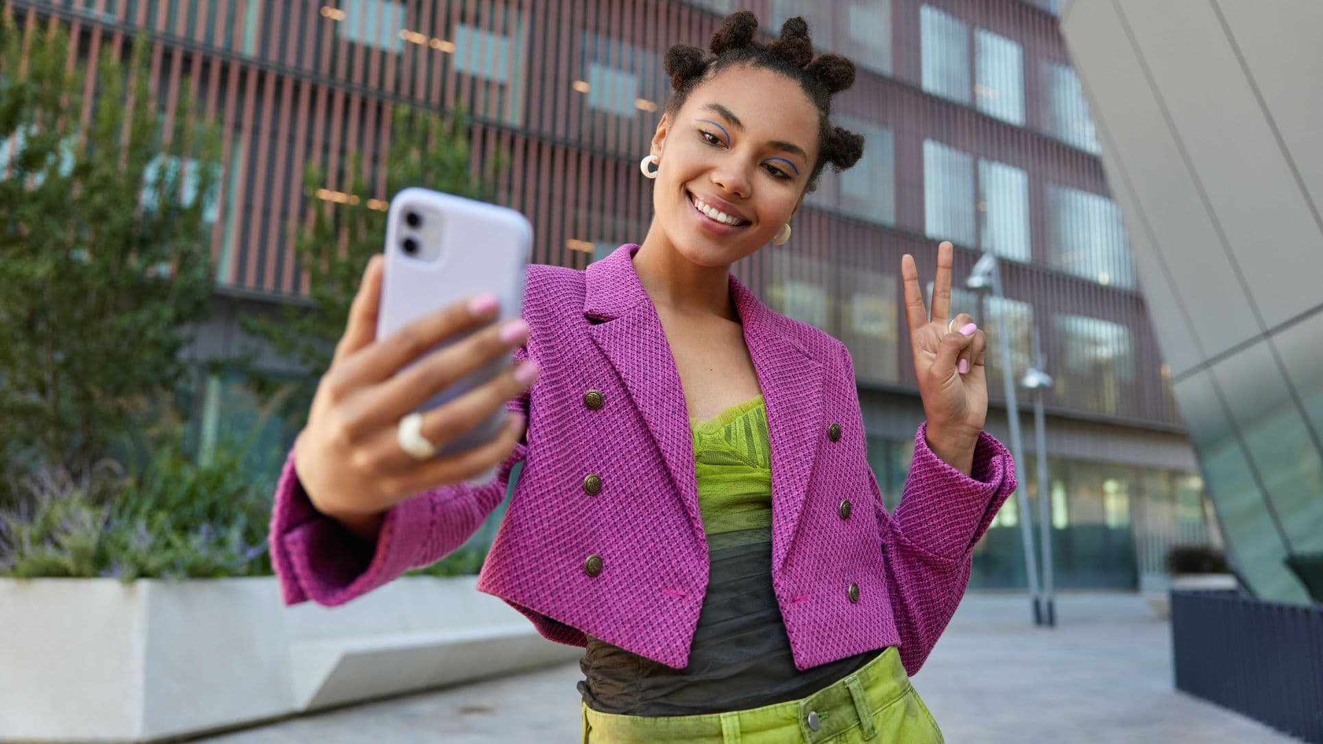 attractive-girl-fashionable-outfit-creats-influence-content-shows-peace-sign-smartphone-front-camera-poses-selfie-smiles-gladfully-poses-urban-place-spends-vacation-big-city_optimized (1).jpg